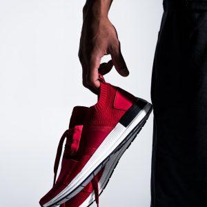 close-up-partial-view-of-african-american-sportsman-holding-sports-shoes-isolated-on-grey.jpg