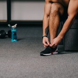 cropped-view-of-man-tying-shoelaces-on-sneaker-in-living-room.jpg